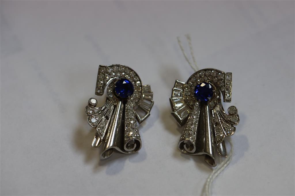 A pair of diamond and sapphire clips in white metal settings (tests as platinum), white metal fitments (three diamonds missing),